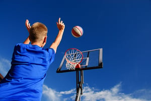 Boy shooting ball into basketball hoop