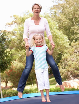 Parent and child benefit from jumping on a trampoline together, it is a fun bonding experience.
