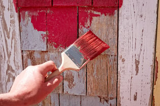 Hand painting a shed.